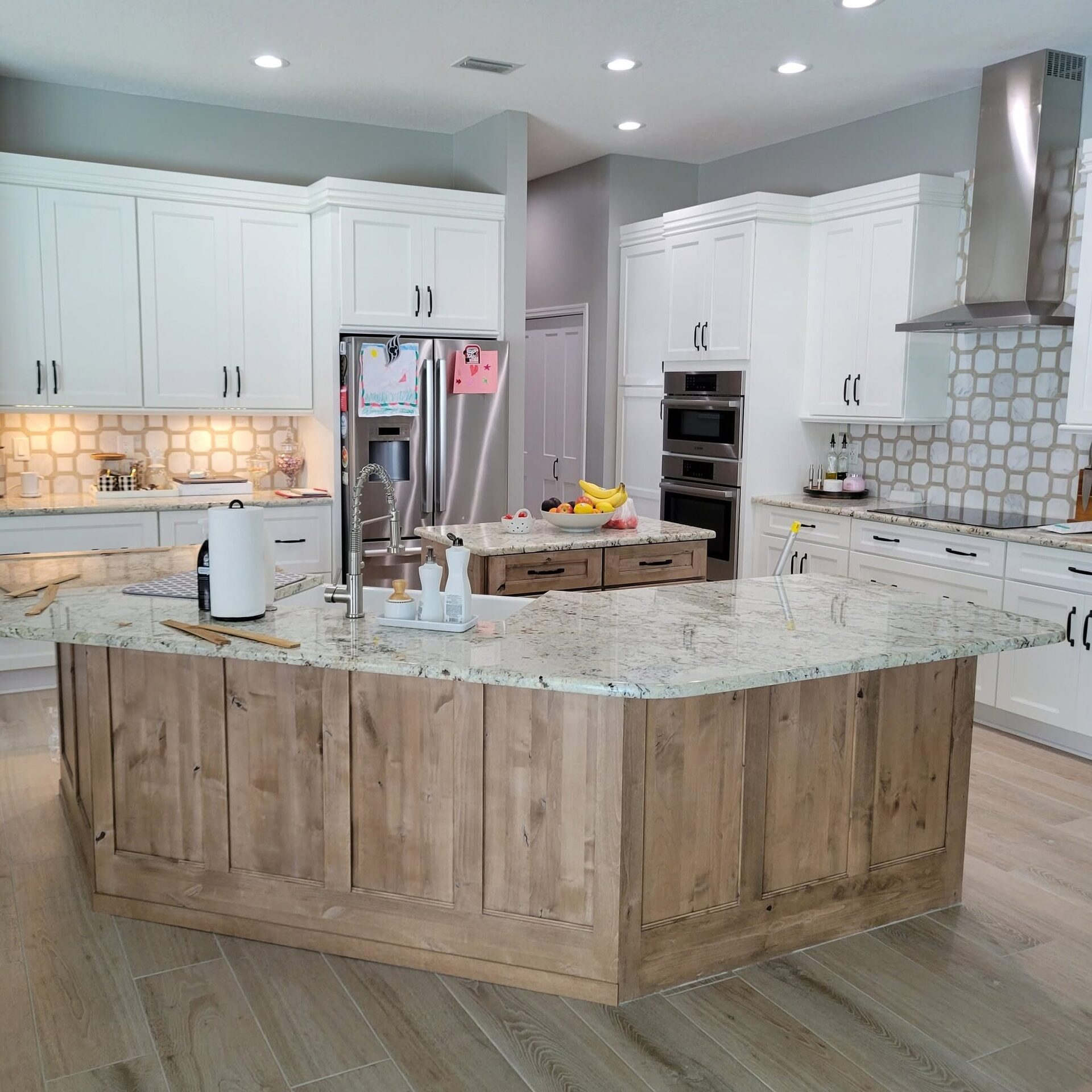 A finished white shaker kitchen with a reclaimed-wood island, remodeled by Reliant Service Team