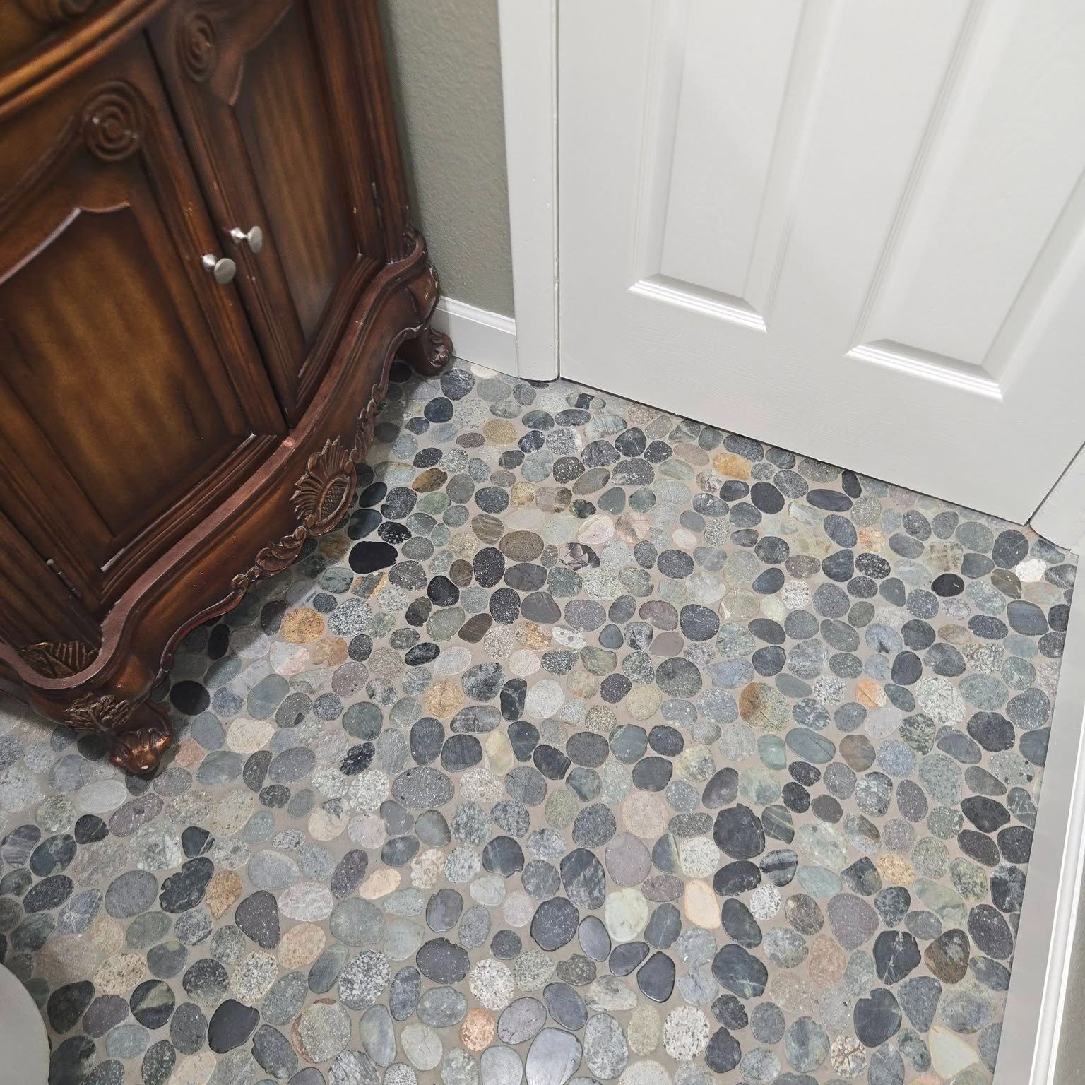 A pebble-tile entry floor finished by Reliant Service Team