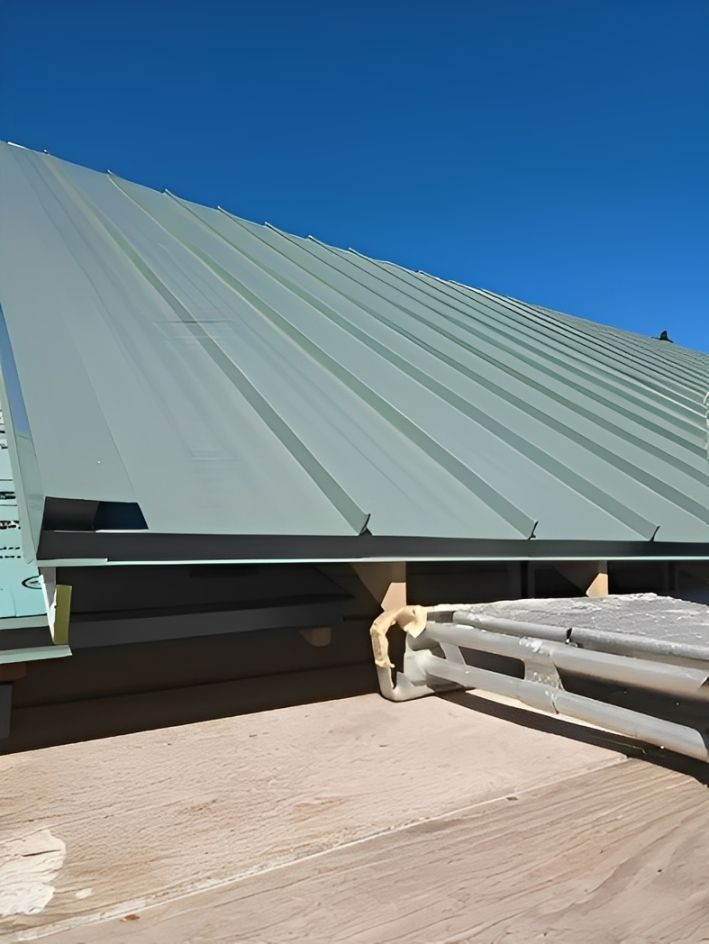 A standing-seam metal roof against a clear sky